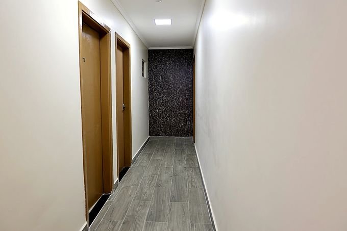 Corredor de acesso aos quartos do Hotel Costa, com piso laminado