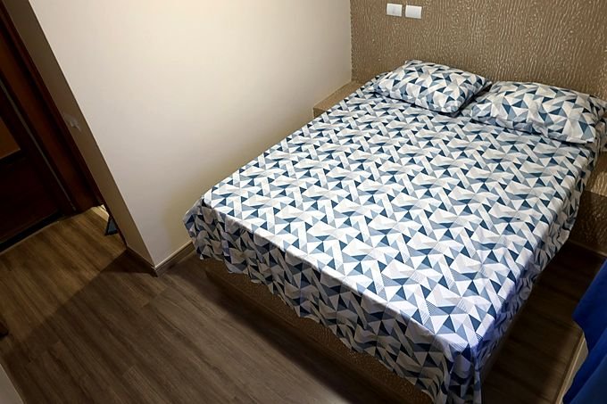 Quarto de casal do Hotel Costa visto da porta, com piso laminado