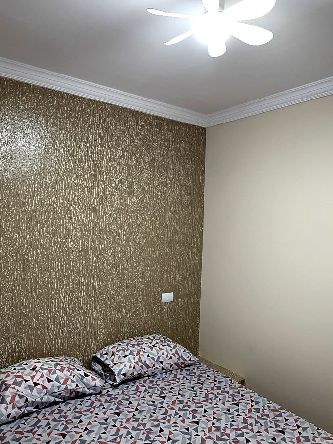 Quarto do Hotel Costa com ventilador de teto e cama de casal arrumada